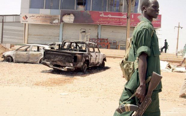 Een Sudanese militair bij een door een aanslag van rebellengroep JEM verwoest gebouw Khartoem. Foto EPA