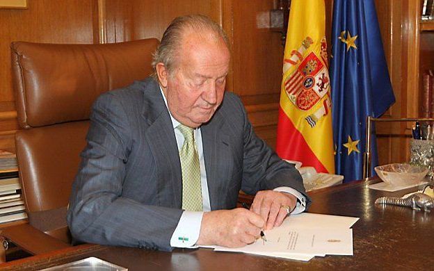 Juan Carlos tekent maandag de brief waarmee hij zijn abdicatie bekendmaakt. beeld AFP