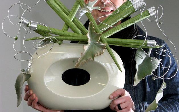 ESSEN – De Duitse trendwatcher Manfred Hoffmann showt een arrangement van sansevieriabladen in een grijze pot. „We noemen het Grauzeit Farbe. Een blikvanger in ieder interieur.” Op de grootste bloemen en plantenbeurs van Europa is het vaderlandse groen ri