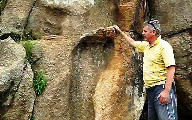 Michael Tellinger bij de reusachtige voetafdruk in de granieten rotspartij bij Mpuluzi in Zuid-Afrika. Foto YouTube