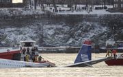 NEW YORK - De Airbus 320 wordt boven water gehouden door touwen die aan de omliggende boten vast zitten. Foto EPA
