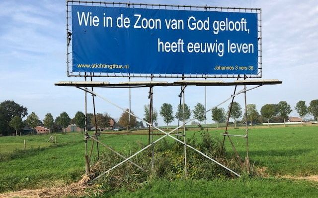 In een weiland bij Hattem, vlak langs de A28, is een groot spandoek geplaatst met een Bijbeltekst uit Joh. 3:36. beeld Stichting Titus