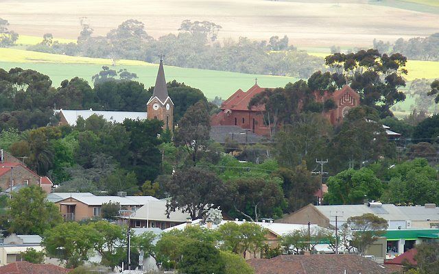 De anglicaanse (links) en rooms-katholieke kerk (rechts) in de Zuid-Australische stad Kapunda. Foto Fairv8, Wikimedia