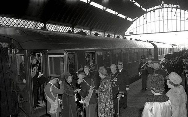 Koning Bhumibol (l.) en prinses Sirikit van Thailand stappen uit de koninklijke trein tijdens een staatsbezoek in Nederland in 1960. - Foto Spaarnestad