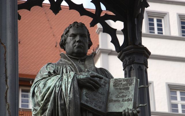 WITTENBERG – Een geopende Bijbel, daar ging het bij Maarten Luther om. Het standbeeld van de Duitse kerhervormer staat in Wittenberg, de stad waar hij op 31 oktober 1517 zijn 95 stellingen aan de deur van de slotkapel bevestigde. Dinsdag beginnen officiee