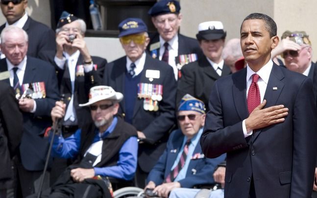 COLLEVILLE-SUR-MER - Obama luistert samen met veteranen naar het Amerikaanse volkslied tijdens de herdenking van D-day. Foto EPA