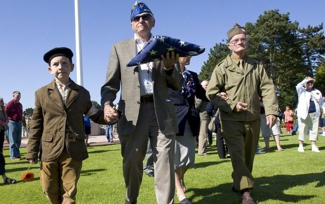 COLLEVILLE-SUR-MER – De Amerikaanse oorlogsveteraan William Tritt van de 82nd Airborne 508 PIR-unit vouwde donderdag tijdens een herdenkingsplechtigheid op de Amerikaanse militaire begraafplaats in Colleville-sur-Mer een Amerikaanse vlag dicht. Foto's EPA