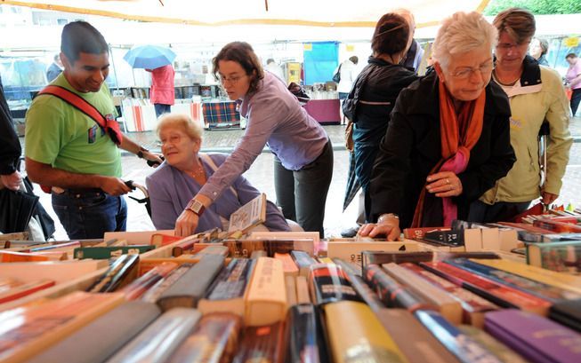 Duizenden boeken neergekwakt op houten tafels. De meeste wil niemand hebben. Foto ANP