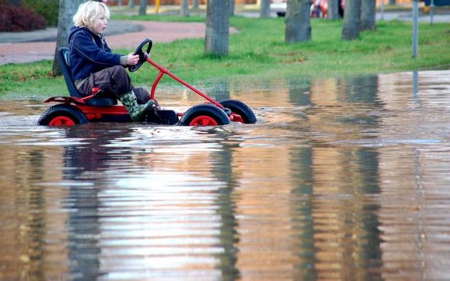 APELDOORN – Overlast als gevolg van extreme, zeldzame buien zal in de toekomst vaker voorkomen. De burger zal moeten wennen aan het feit dat er geregeld water op straat kan staan. Foto: een volgelopen straat na wateroverlast in Apeldoorn, enkele jaren gel