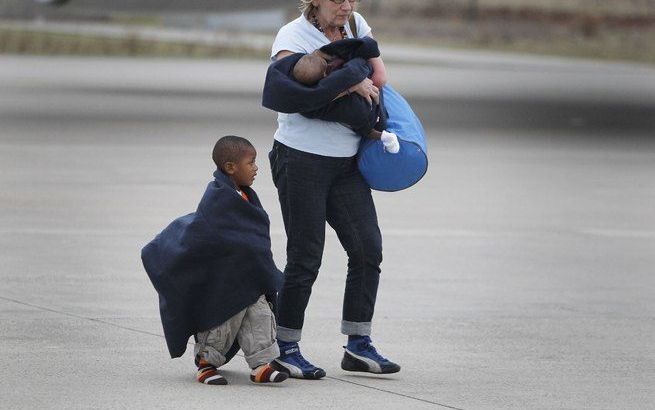 Adoptiekinderen uit Haiti worden na aankomst op vliegbasis Eindhoven weggeleid van het vliegtuig. Het toestel met aan boord 106 Haïtiaanse weeskinderen kwam donderdag aan op de vliegbasis. In totaal 92 kinderen werden opgevangen door Nederlandse adoptieou