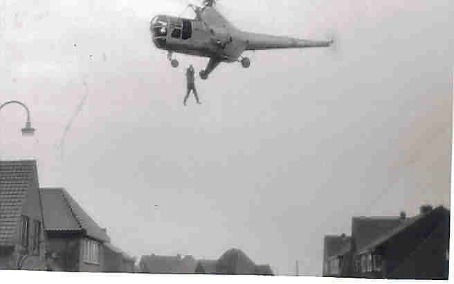 Een journalist in Kruiningen fotografeerde Koos Francoys terwijl hij aan een kabel werd opgehesen vanaf het dorpsplein. Foto uit collectie J. J. Francoys