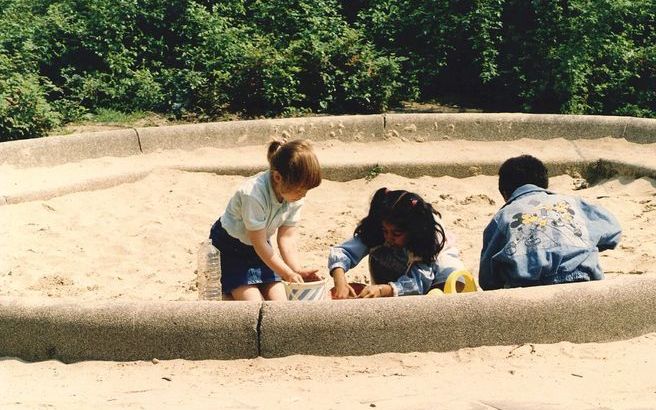 Spelende kinderen in zandbak. - Foto ANP