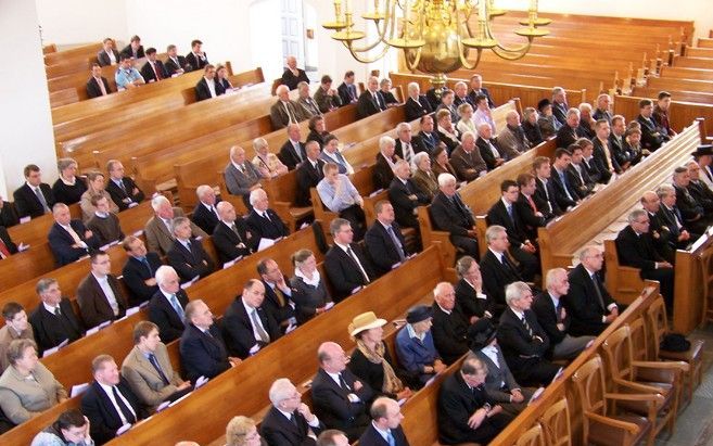 PUTTEN - SGP' ers luisteren naar fractievoorzitter Van der Vlies in de Oude Hervormde kerk te Putten, waar hij zaterdag een rede uitsprak ter gelegenheid van het negentigjarig bestaan van de partij. Foto's RD.