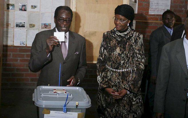 HARARE – De Zimbabwaanse president Robert Mugabe (l.) bracht gisteren onder toeziend oog van zijn vrouw Grace Mugabe (r.) zijn stem uit op een stembureau in Harare. Foto EPA