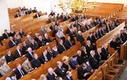 PUTTEN - SGP' ers luisteren naar fractievoorzitter Van der Vlies in de Oude Hervormde kerk te Putten, waar hij zaterdag een rede uitsprak ter gelegenheid van het negentigjarig bestaan van de partij. Foto's RD.