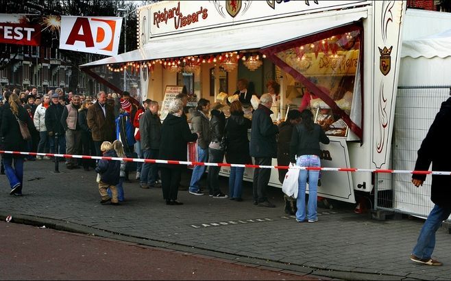 ROTTERDAM - Bij verschillende oliebollenkramen staan zaterdag mensen in de rij om oliebollen te kopen. Bij de kraam van Richard Visser is het erg druk en staan er lange rijen voor de kraam. Foto ANP