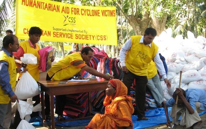 DHAKA – Medewerkers van CSS, een christelijke hulporganisatie in Bangladesh, delen hulpgoederen aan slachtoffers van de cycloon Sidr. Foto EPA