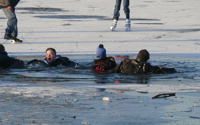 URK - In een vijver in Urk zijn zaterdag drie kinderen door het ijs gezakt. Toen omstanders hen wilde redden raakten zij ook te water. Foto J. Pasterkamp.