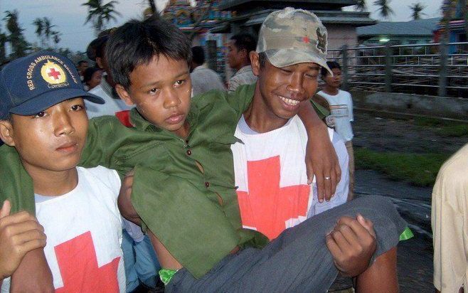 Medewerkers van het Rode Kruis dragen een gewonde jongere weg bij Bogala in de Irrawaddydelta, Birma. Foto EPA/Internationale Rode Kruis