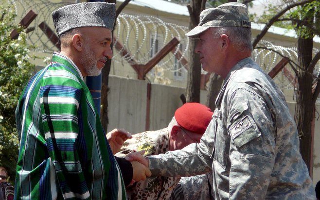 KABUL – De Afghaanse president Karzai (l.) schudde gisteren de nieuwe bevelhebber van de internationale troepenmacht ISAF, de Amerikaanse generaal David McKiernan, de hand. McKiernan nam gisteren het bevel over van zijn landgenoot Dan McNeill. Foto EPA