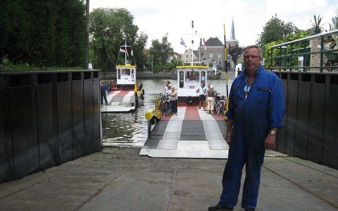 GOUDERAK – Gert Bouter, scheidend veerbaas: „De veerdienst is een stuk van mijn leven. Ik vaar nog altijd graag.” Op de achtergrond ligt het pontje in Gouderak klaar om te vertrekken richting Moordrecht. Veel auto’s rijden achteruit het pontje op, om aan 