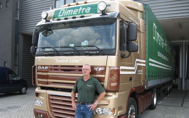 SCHERPENZEEL – Vrachtwagenchauffeur Breunie Ploeg (51) voor de truck waarmee hij elke week naar Zwitserland rijdt. Achter de voorruit van de truck zijn drie tolkastjes te zien: apparaten waarmee in Duitsland, Oostenrijk en Zwitserland automatisch tol word