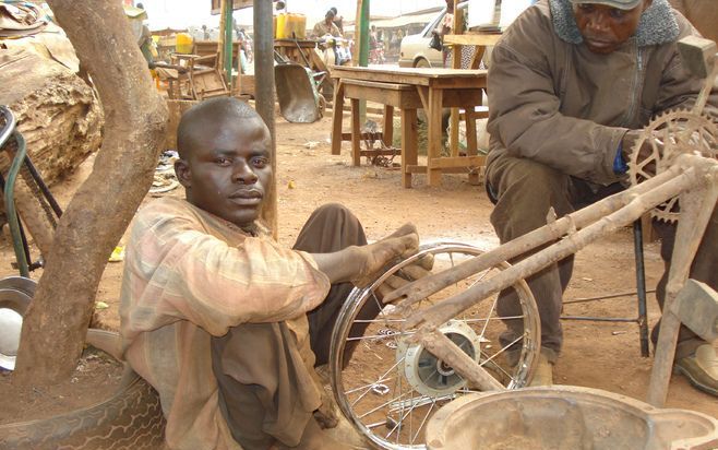 Een lichamelijk gehandicapte Nigeriaan is fietsenmaker dankzij het re-integratieproject van Stichting Elim. „Gehandicapten hebben nu een meer volwaardige plaats in de samenleving.” Foto Stichting Elim