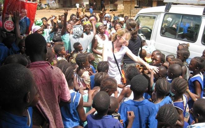 FREETOWN – Brechtje van Lith omringd door tientallen kinderen tijdens een veldbezoek in Sierra Leone. Foto War Child