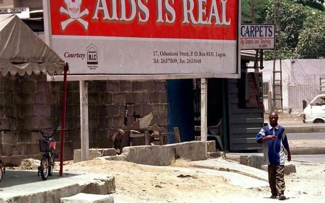 Een groot bord in de zuidelijke Nigeriaanse miljoenenstad Lagos waarschuwt voor het reële gevaar van aids. In Nigeria zijn naar schatting 2,6 miljoen mensen besmet met het hiv virus. „Je moet hier aidswerk doen met argumenten ontleend aan de heilige boeke