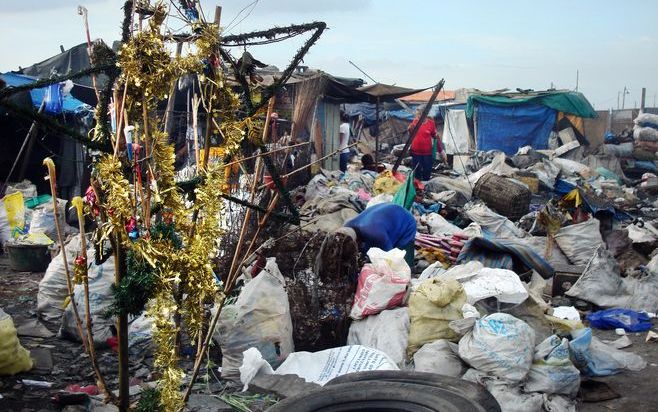 Op Smokey Mountain II, de vuilnisbelt van Manilla, zorgen de bewoners ook alvast voor wat kerstsfeer. Maar hun kerstdiner komt later. Zodra afgedankte kerstbouten van de rijken tussen het vuilnis opduiken. - Foto’s RD