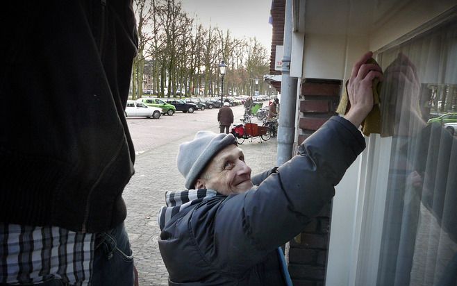 UTRECHT – De Utrechtse drugsverslaafde Paul zeemt ramen bij een van de huizen aan de chique Maliebaan. Met een heitje voor een karweitje zamelt hij geld in voor Unicef. - Foto RD