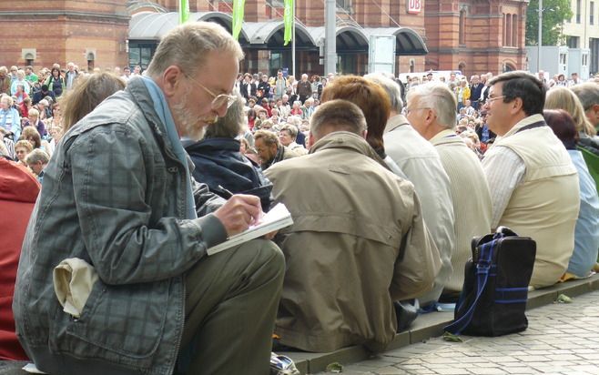 BREMEN - Een man luistert aandachtig voor het treinstation naar een „Morgengebete”. Elke dag van de vijfdaagse Kirchentag wordt geopend en gesloten met samenkomsten verspreid over de stad. Foto RD