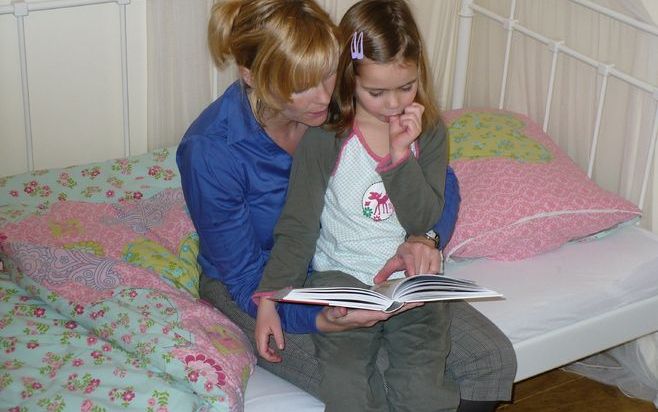 Jolanda ten Hoope leest met haar dochter Anouk (5) uit de kinderbijbel. Met een reeks Bijbelstudieboekjes vestigde uitgeverij De Banier dit voorjaar de aandacht op het Bijbellezen in het gezin. Ook de Hervormd Gereformeerde Jeugdbond bezint zich hierop. F