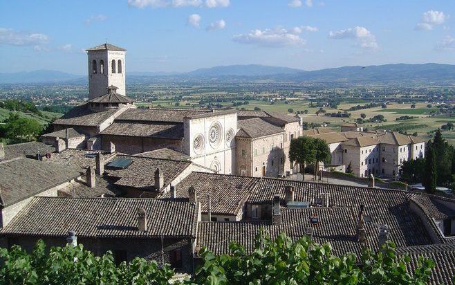 De basiliek van Santa Chiari in Assisi. Beneden ligt het dal van Spoleto, waar Franciscus het vervallen kerkje van San Damiano herstelde. Even verderop, in Portiuncula, hoorde hij van een priester dat de leerlingen van Christus geen goud, zilver of geld m