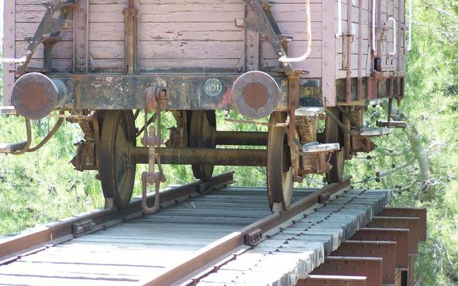 Ze lopen uit op een afgrond, de rails met daar bovenop de originele veewagon waarin naamloze Joden hun dood tegemoet reden. De Poolse autoriteiten schonken de wagon aan Yad Vashem. ”Deutsche Reichsbahn, München”, staat er op de zijkant. Het is een van de 