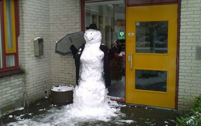 Het Centraal Bureau Gereformeerde Gemeenten in Woerden wordt sinds de lunchpauze bewaakt door een gepaste sneeuwpop. Foto Laurens Kroon