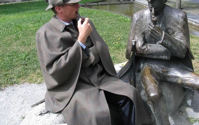 De Nederlandse hotelbaas Ferdinand T. Salverda, verkleed als Sherlock Holmes, naast een standbeeld van de superspeurder in het Zwitserse bergdorp Meiringen.