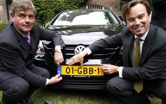 DRIEBERGEN - Minister Eurlings (r) reikt maandag in Driebergen het eerste nieuwe nummerbord uit aan de eigenaar. Foto ANP