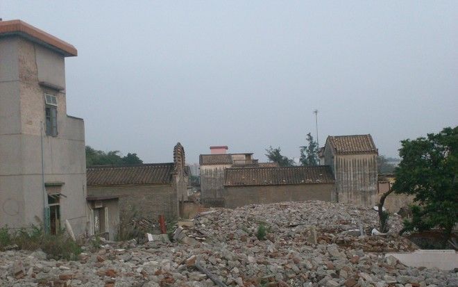 Het dorp Guanzhou –voor zover men nog van een dorp kan spreken– ligt ongeveer 200 meter van de ingang van het metrostation. De meeste gebouwen liggen in puin. Foto Paul van Benthem