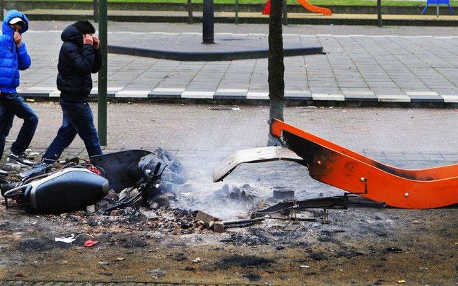 Een scooter en een glijbaan smeulen nog na op 1 januari in de Haagse Schildersbuurt. Foto ANP