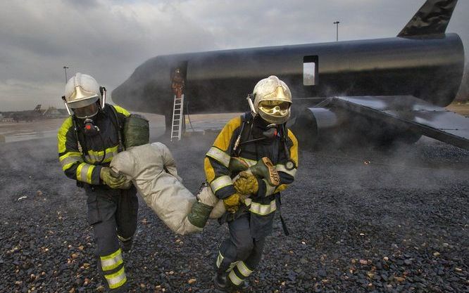 WOENSDRECHT – Twee Afghaanse brandweerlieden na de redding van een slachtoffer uit een brandende Boeing 737 op de brandoefenlocatie van de vliegbasis Woensdrecht. Tien Afghanen worden getraind in de bestrijding van brandhaarden onder realistische omstandi