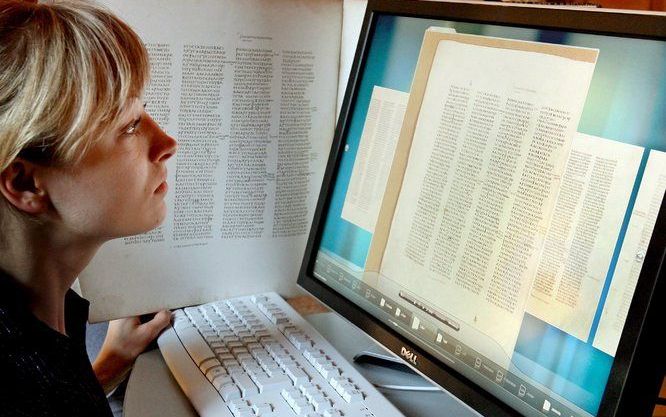 Een vrouw bekijkt een gescande pagina van de oudste Bijbel ter wereld, de Codex Sinaiticus, in de universiteit van Leipzig. Foto EPA