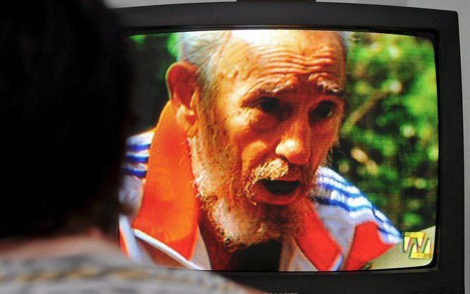 HAVANA - Een vrouw kijkt naar tv-beelden van de zieke Fidel Castro, die voor het eerst sinds januari weer op televisie verscheen. Castro had een ontmoeting met de Venezolaanse president Hugo Chàvez. Foto EPA