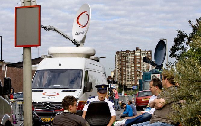 DEN HAAG - Een agent wacht samen met journalisten voor de poort van de Scheveningse gevangenis in Den Haag waar men wacht op de komst van Radovan Karadzic. In de nacht van maandag op dinsdag waren de beste cameraposities om zijn komst te filmen al vergeve