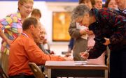 De eerste kiezers registreren zich bij een stembureau in Indianapolis. Foto EPA