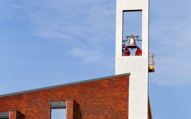 Met een grote kraan is vrijdagochtend een klok opgehangen in de toren van de nieuwe kerk van de gereformeerde gemeente in Sliedrecht. Foto Dirk Hol