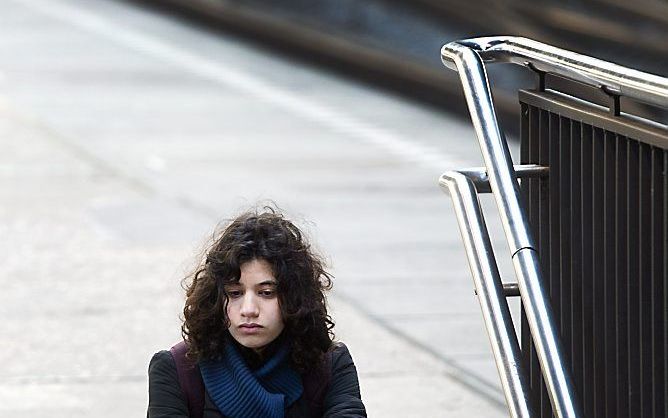 Een wachtende reiziger op Amsterdam Centraal. Foto ANP