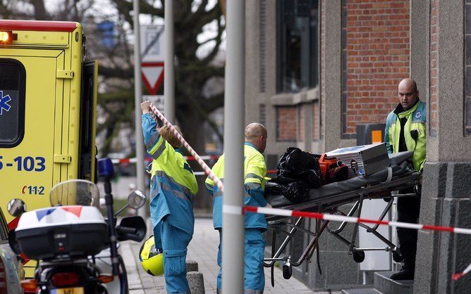 DEN HAAG - Ambulance-personeel tilt een ongebruikte brancard naar buiten vanuit het Orange-gebouw. Een medewerker van telecombedrijf Orange is vrijdag door een collega doodgestoken. Het incident vond plaats in een kantoor van het bedrijf aan de Groenhoven