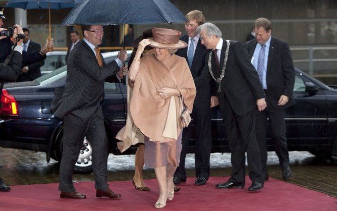 DEN HAAG – Commissaris van de koningin Franssen (l.) van Zuid-Holland en burgemeester Van Aartsen van Den Haag (r.) verwelkomen koningin Beatrix bij een jubileumbijeenkomst ter gelegenheid van het vijftigjarig bestaan van het Nederlands Genootschap van Ho