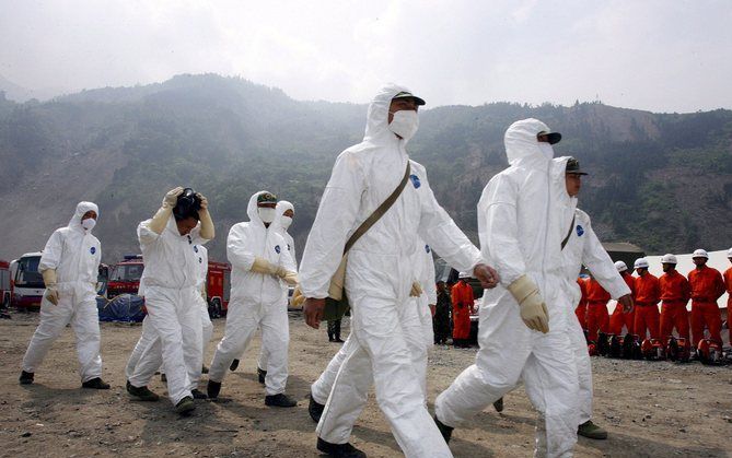 YINGXIU - Zelfs twee weken na de ramp werken in Yingxiu nog altijd zo’n 3000 troepen 24 uur per dag om lichamen te vinden en te bergen. Groepjes van vier tot acht militairen, de meeste in witte, beschermende kleding, dragen voortdurend zakken met lichamen